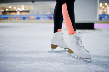 Legs of ice skater on the ice rink.