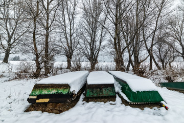 Naklejka premium A boats covered with snow on the coast