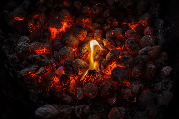Coals of a bonfire burning at night .