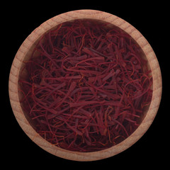 red fresh saffron in wooden cup isolated on black background.  top view