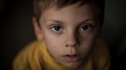 closeup portrait of cute face of afraid little boy
