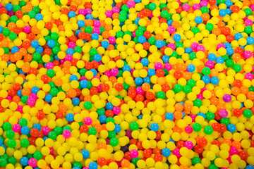 Fototapeta na wymiar Ball pool in the children's playroom. colorful plastic balls on children's playground. Colorful plastic gum balls background in kid playroom or playground for children's holiday party