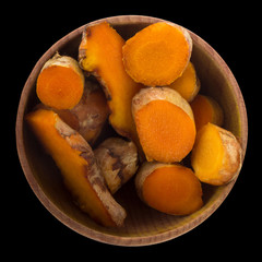 turmeric  in wooden cup isolated on black background.  top view