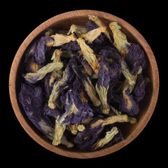 Clitoria ternatea in wooden cup isolated on black background.  top view