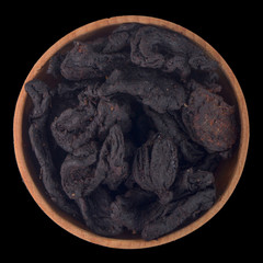 dried Garcinia in wooden cup isolated on black background. top view