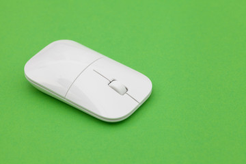 White wireless optical mouse with a wheel on a green background. Modern concept for the Internet...