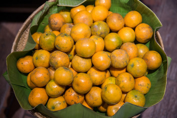 Many fresh and beautiful Oranges with a good taste in the basket at the market. Many orange put on shelves in the market. 