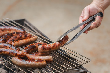 Grilling sausages on barbecue grill outdoor