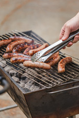 Grilling sausages on barbecue grill outdoor