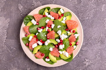Tasty salad with grapefruit, spinach, feta, avocado and pomegranate