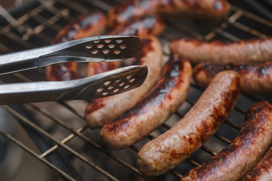 Grilling sausages on barbecue grill outdoor