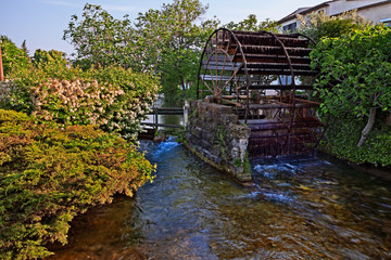 L'Isle-sur-la-Sorgue, Vaucluse,.Avignon, France: view of the canal with the wheel of the old water mill © ermess