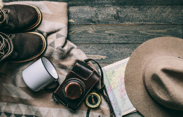 vintage camera hat and rustic-style plaid on a dark background vintage stuff and old compass things to travel in the mountains