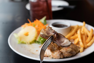 chicken steak with French fries and sauce on table

