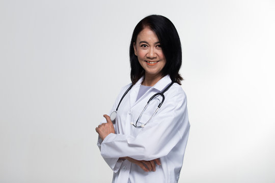 Asian Beautiful Senior Doctor Nurse woman in uniform with stethoscope in Medical hospital, portrait 50s 60s years old aging society make up black short hair, studio lighting gray background copy space