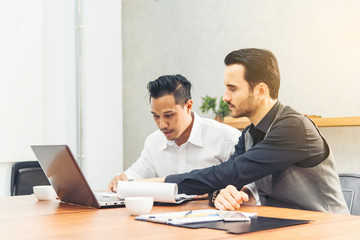 Obraz premium Two professional businessman discussing working project together with laptop at modern office .Teamwork business and finance people colleagues co-workers with technology concept