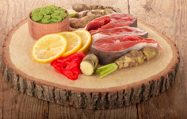  humpback salmon slices with spices on stub on wooden background