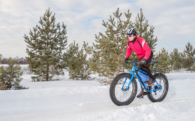 A young man riding fat bicycle in the winter. Fat tire bike.
