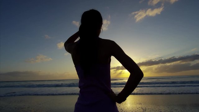 Asian Chinese American girl with sport watch on the sand by sea doing fitness