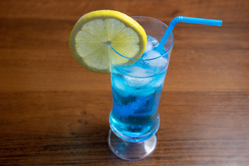 Blue Lagoon cocktail in highball glass with a straw