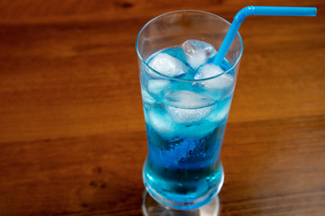 Blue Lagoon cocktail in highball glass with a straw