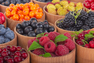berries in wooden cups on wooden background