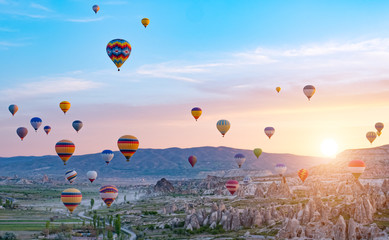 Colorful hot air balloons flying over rock landscape at Cappadocia Turkey