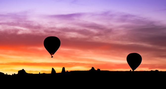 Hot air balloon silhouette in mountains at sunrise, Goreme, Cappadocia, Turkey