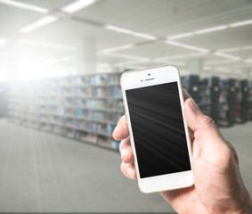 Closed up right hand holding mobile smart phone/ cell phone with copy space ,blank screen for text and content with clipping path,blurred background of office / Library indoor