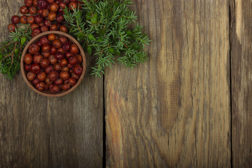 heap of red juniper berries on wooden background. top view