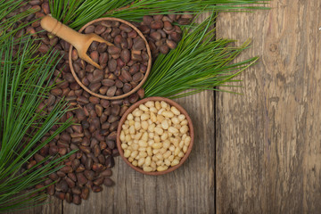 cedar nuts in wooden cups on wooden background