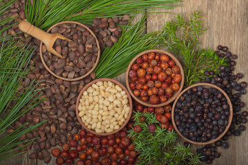 cedar nuts and juniper berries on wooden background