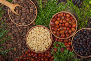 cedar nuts and juniper berries on wooden background