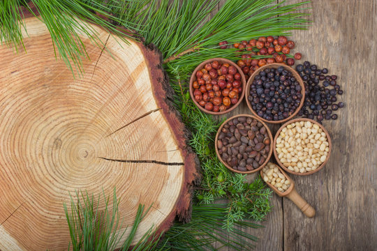 cedar nuts and juniper berries on wooden background © lewal2010