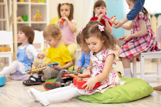 Children group learning musical instruments on lesson in kindergarten