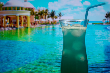 Fototapeta na wymiar Blue Hawaii cocktail in hurricane glass with a straw and ice