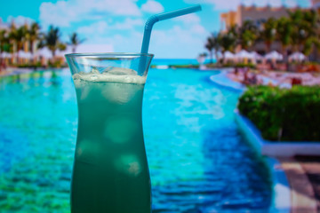 Fototapeta na wymiar Blue Hawaii cocktail in hurricane glass with a straw and ice