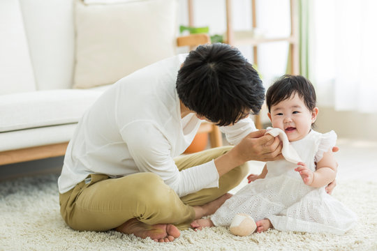 赤ちゃんの顔を拭く父親