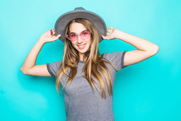 Young pretty woman in sunglasses and fluppy hat isolated on pastel blue background