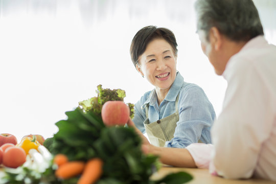野菜を持って笑顔のシニア夫婦