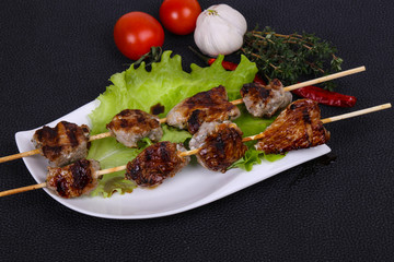 Pork kebab skewers in the plate with salad leaves and tomatoes