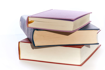 Three books close-ups of different colors lie on top of each other.  background white