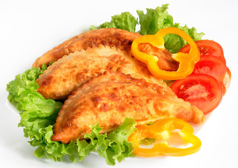 Chebureks on lettuce leaves on a white background