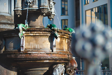 Closeup of green lizards and dwarf head on the Cholerabrunnen