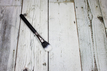 Microfiber makeup brush on a light wooden background