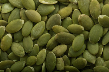 heap of shelled pumpkin seeds background