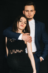 fashionable young married couple posing stylishly. Caucasian man and pregnant woman