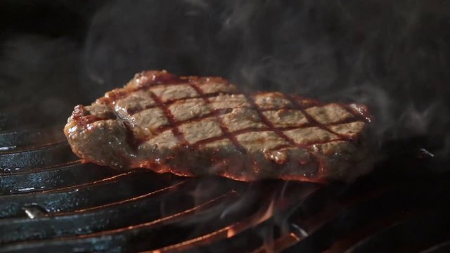 cooking meat steak on the grill on fire