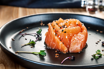 Close up view on salted salmon on black plate. Healthy food for menu. Free copy space. Healthy diet background