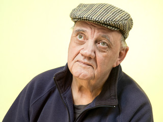 portrait homme âgé inquiet sur fond jaunâtre